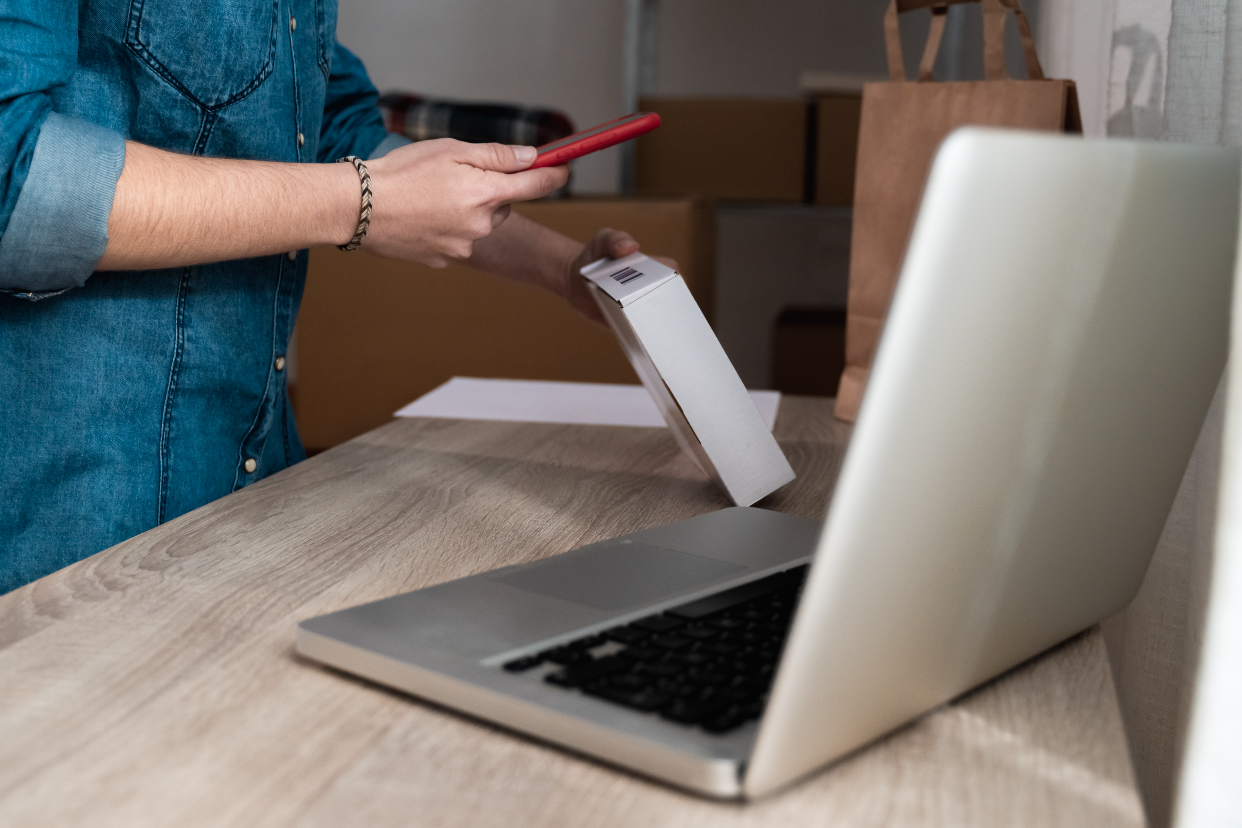 A person scans a package with smart packaging using their smartphone, highlighting the integration of technology in modern packaging solutions.