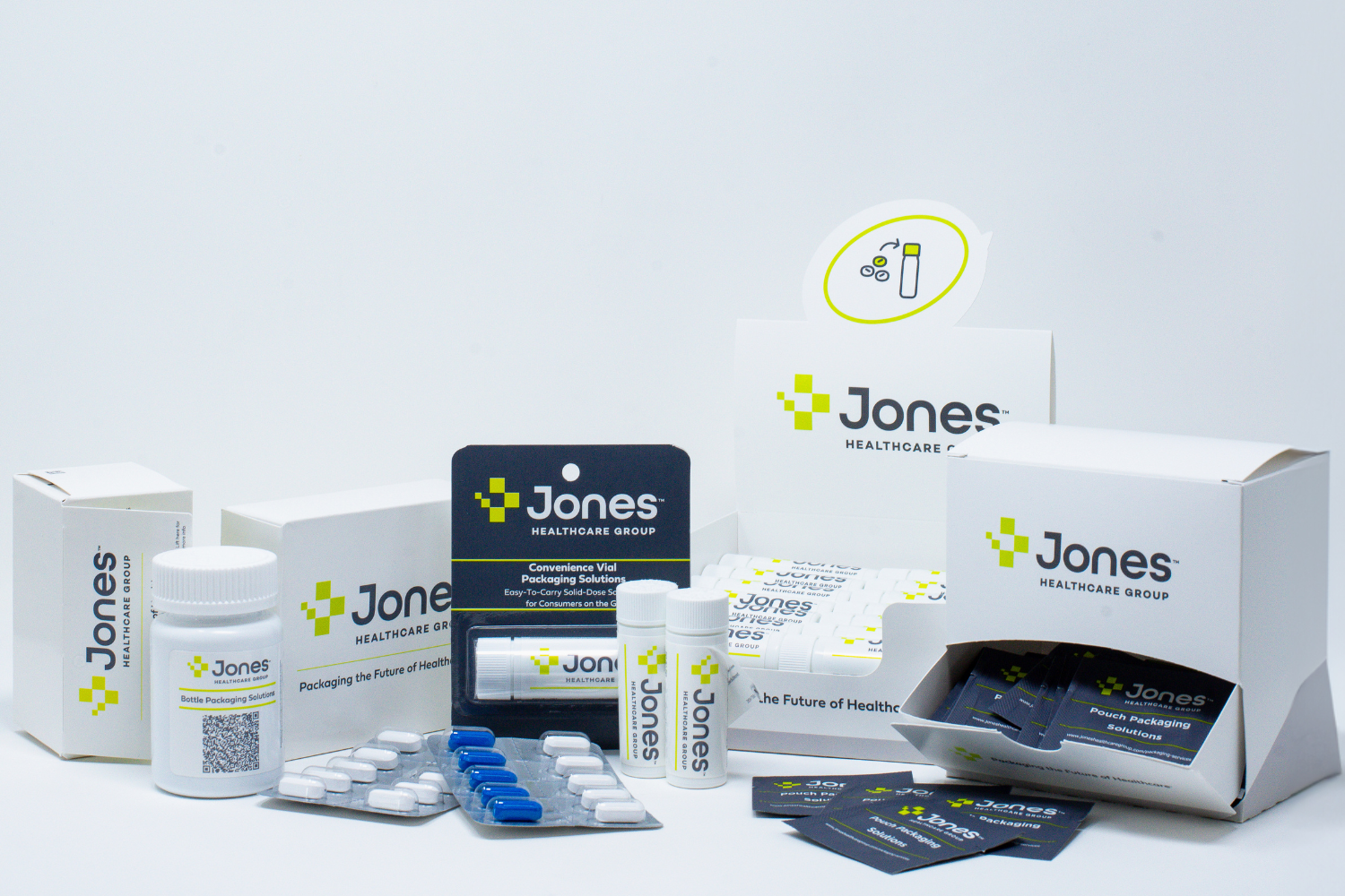 A display of various Jones Healthcare Group products including boxes of pills, blister packs, and bottles of medications, showcasing a range of pharmaceutical packaging.